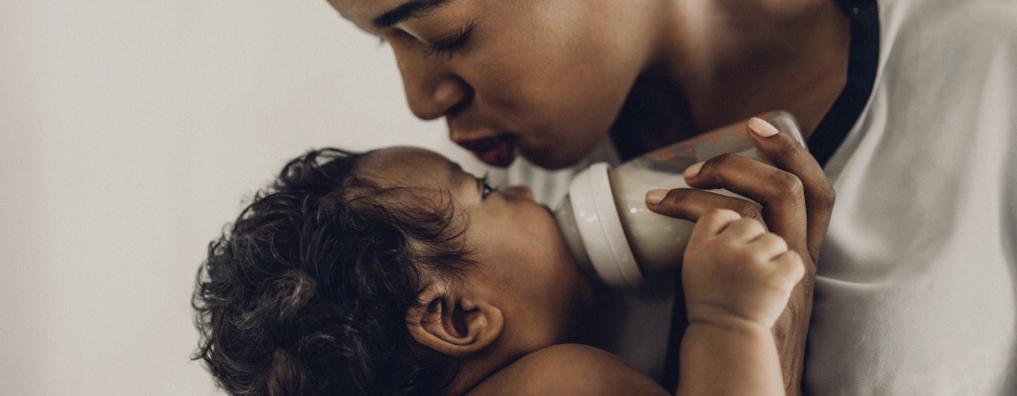 representation of black motherhood with mom kissing and feeding her baby