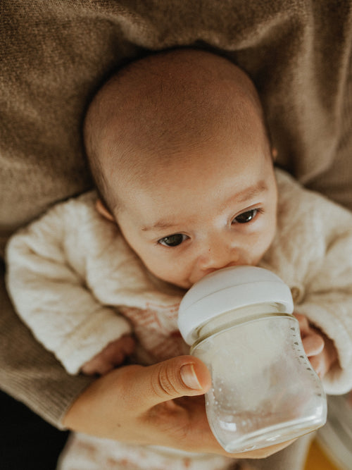 baby looking off while drinking bottle