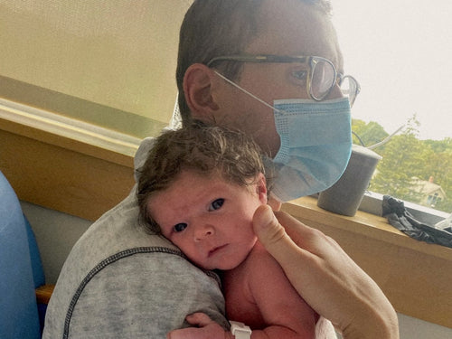 newborn being held by dad in hospital 