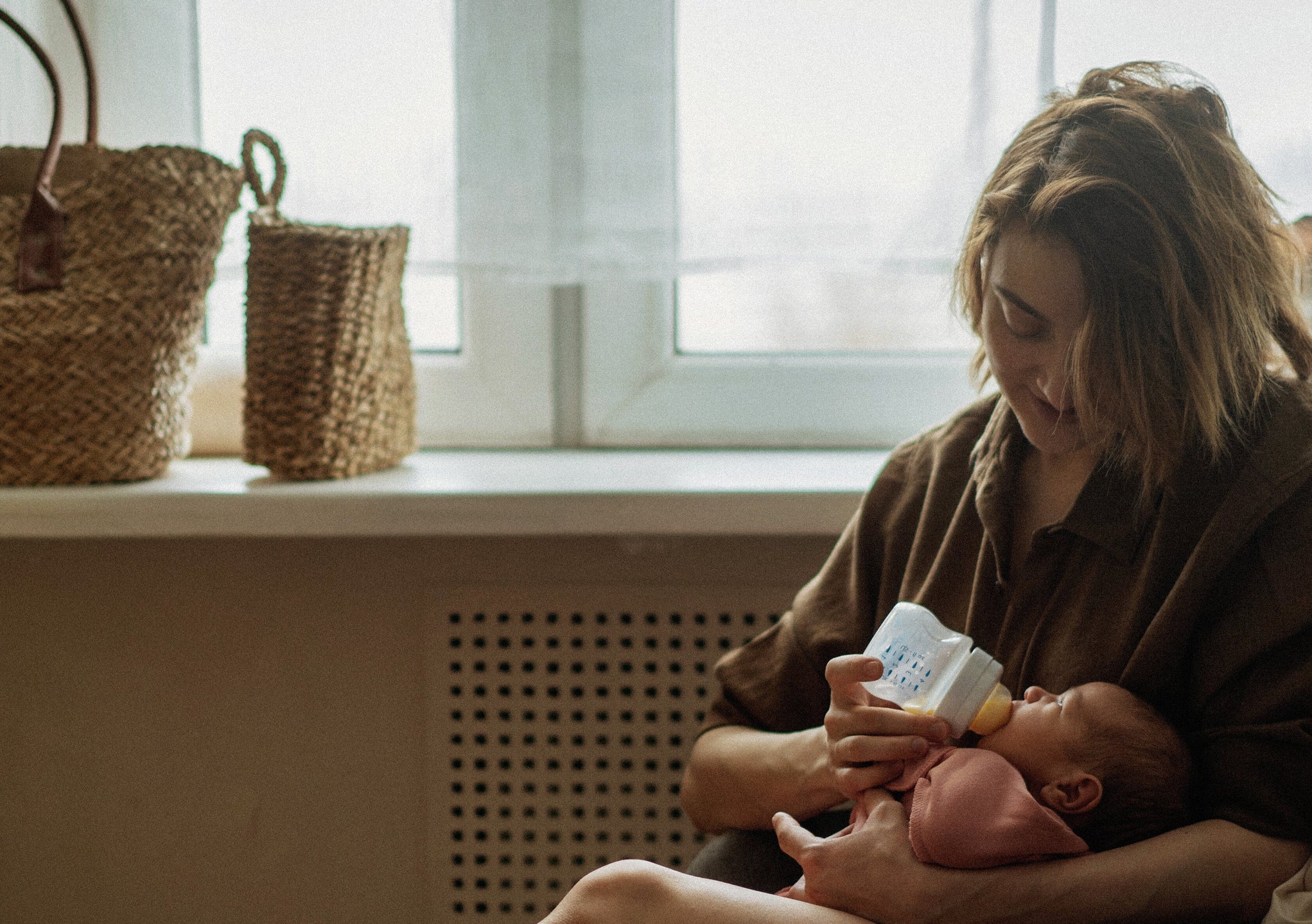 representation of a working mom feeding her baby with a bottle