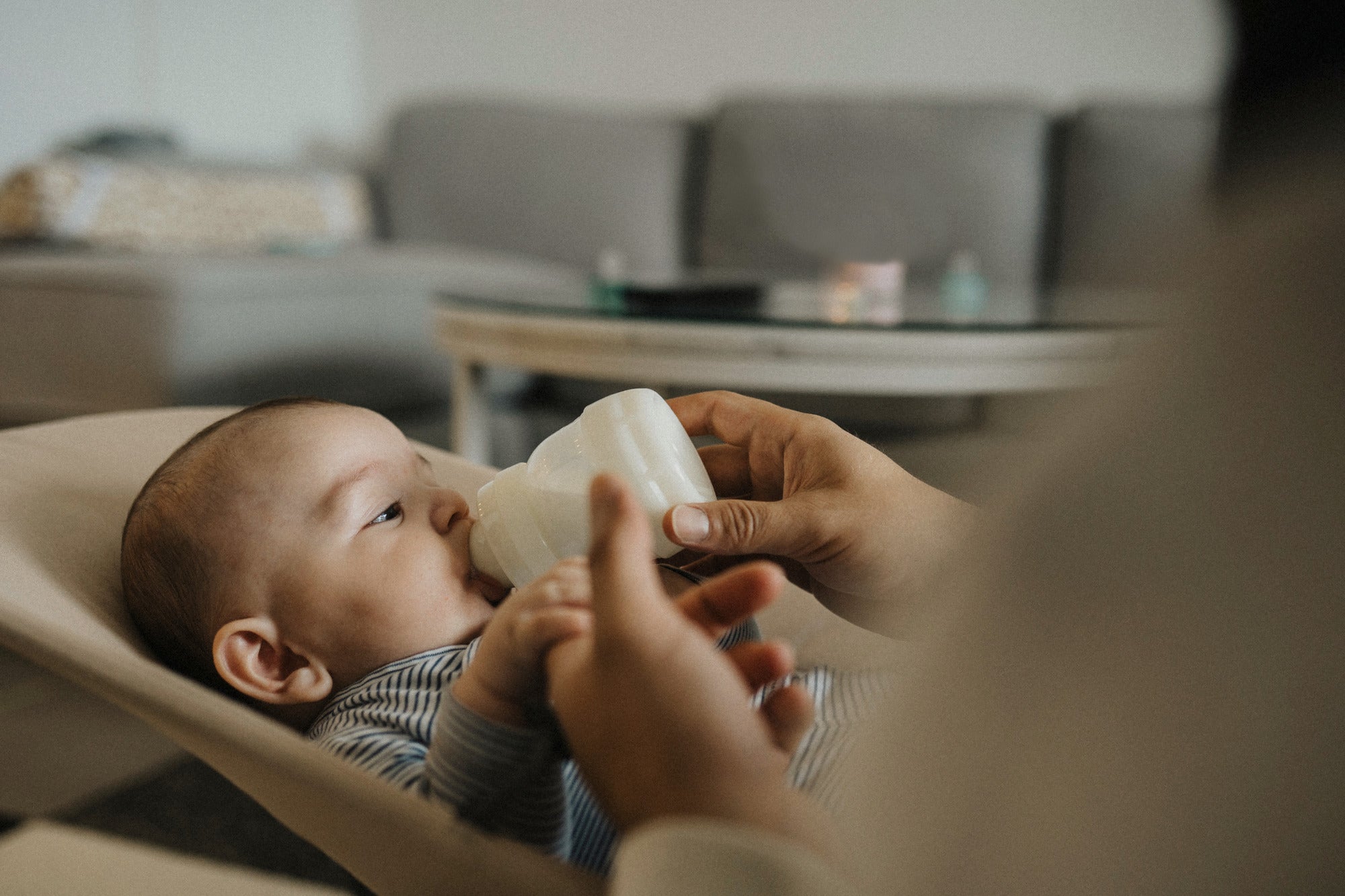 Baby drinking bottle in a baby chair